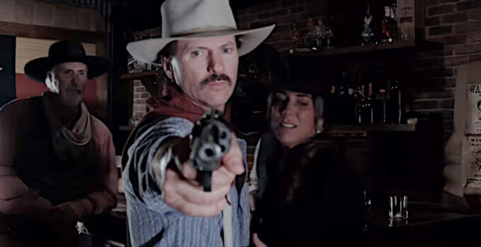 Matt Malone as Colt Williams, protecting Angel (Michelle Malone) from ruffians in the saloon in Denison in The Whore and the Horseman (2025)